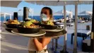  ??  ?? Una camarera, este verano, en una terraza de la playa de Palma de Mallorca.