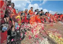  ?? REUTERS/P. RAVIKUMAR ?? Women scatter flower petals in the waters of the Bay of Bengal during a prayer ceremony for the victims of the 2004 tsunami on the 15th anniversar­y of the disaster, at Marina beach in Chennai, India, on Thursday.