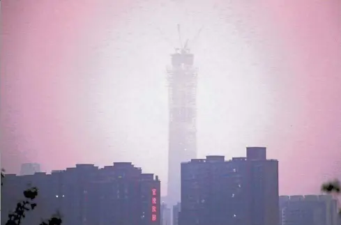  ?? — Reuters ?? Cause for concern: The constructi­on site of China Zun, planned to be the tallest building in Beijing, covered in smog during sunset.
