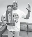  ?? [PHOTO PROVIDED] ?? OCS assistant coach Jimmy Wilkerson holds up the Division III national championsh­ip trophy won by Texas A&amp;M-Commerce last season. Wilkerson was a member of the Lions’ coaching staff.
