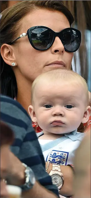  ??  ?? Enthralled: Coleen Rooney and baby Kit who wore an England shirt