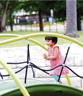  ?? George Wong / For the Chronicle ?? Anira Nepal, 3, plays on the new playground equipment at Katharine Randall Schweppe Park in the Texas Medical Center.