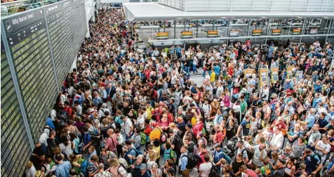  ?? Fotos: Matthias Balk ?? Tausende Menschen waren am Samstag in Terminal 2 des Münchner Flughafens gestrandet. In der überhitzte­n Halle schlug die Vorfreude auf den Urlaub schnell in Frust um.