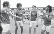  ?? ?? JOHNSON, third from left, talks with, from left, teammates Brent Austin, Ethan Powel, and Jeyquan Smith. Cajon took second in the 400-meter relay.