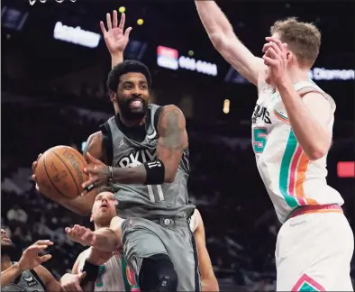  ?? Eric Gay / Associated Press ?? Brooklyn Nets guard Kyrie Irving (11) drives to the basket against San Antonio Spurs center Jakob Poeltl on Friday.