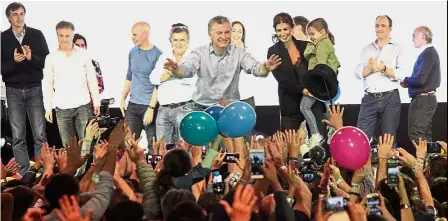  ??  ?? Vital boost: Macri (centre) greeting supporters next to his wife First Lady Juliana Awada (right) and their daughter Antonia during the celebratio­n after legislativ­e elections in Buenos Aires. — AFP