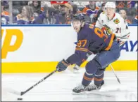  ?? Amber Bracken The Associated Press ?? Oilers center Connor Mcdavid controls the puck with Chicago defenseman Alex Vlasic in pursuit during Edmonton’s 3-0 win Thursday.