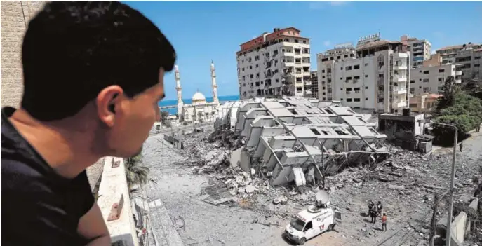  ??  ?? Un palestino mira un edificio destruido en la ciudad de Gaza, tras una serie de ataques aéreos israelíes sobre la Franja