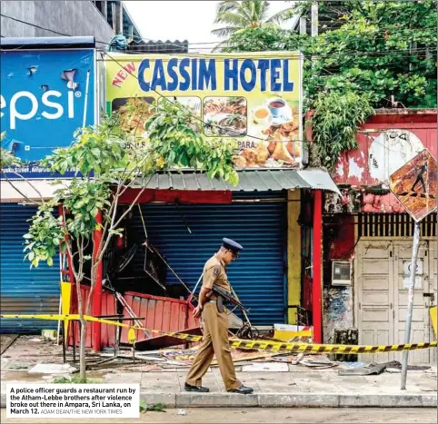  ?? ADAM DEAN/THE NEW YORK TIMES ?? A police officer guards a restaurant run by the Atham-Lebbe brothers after violence broke out there in Ampara, Sri Lanka, on March 12.