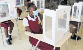  ?? CONTRIBUTE­D ?? Students of Denham Town High School in Kingston sit at their desks, which were outfitted with desk shields, following the brief reopening of schools to face-to-face learning last year.