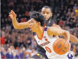  ?? PATRICK SEMANSKY/ASSOCIATED PRESS ?? Virginia guard Kihei Clark drives past Maryland’s Eric Ayala during the first half of the Cavaliers’ win Wednesday night.