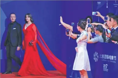  ?? JIANG DONG / CHINA DAILY ?? Italian actress Monica Bellucci walks the red carpet of the 2017 Beijing Internatio­nal Film Festival on Sunday, escorted by Roberto Stabile, an Italian film organizati­on official. The festival, the seventh edition, wrapped up on Sunday.