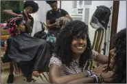  ?? ?? Adriana Heredia poses in front of customers at her Beyond Roots, a private enterprise that includes a clothing store, a beauty salon specializi­ng in afro hair and various other cultural projects, in Havana, Cuba, early last month. (AP/Ramon Espinosa)