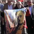  ?? MANU FERNANDEZ — THE ASSOCIATED PRESS ?? A man holds a drawing of Spanish dictator Gen. Francisco Franco as people gather outside Mingorrubi­o’s cemetery in Madrid on Thursday.