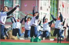  ??  ?? From left: Students from Qingdao Binchuan Road Primary School play on a football pitch. A class of students from the Qingdao Siliu Middle Road No 3 Primary School practice skipping rope.