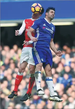  ?? HANNAH MCKAY / REUTERS ?? Chelsea's Diego Costa (right) vies for a high ball with Arsenal's Laurent Koscielny during their English Premier League match at Stamford Bridge in London on Saturday. The Blues won 3-1.