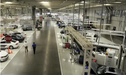  ?? ?? Two Volkswagen employees walk through the axle alignment department in Chattanoog­a, Tennessee.Photograph: Billy Weeks/Reuters