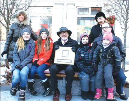  ?? RECORD ARCHIVES/ROSS MURRAY ?? Dr. Bouchard and family members in 2013, seated on the bench dedicated to the doctor following his retirement, honouring his 50 years of service to the community