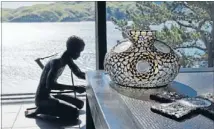  ??  ?? Crafty: Gloria made the candlehold­er out of crystals and gold-coloured glass pebbles. The kneeling African figure was made from recycled petrol cans.