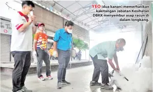  ??  ?? YEO (dua kanan) memerhatik­an kakitangan Jabatan Kesihatan DBKK menyembur asap racun di dalam longkang.