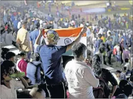  ?? ASSOCIATED PRESS] [MANISH SWARUP/THE ?? A spectator folds an Indian flag as he and others prepare to leave a watch party after that nation’s Chandrayaa­n-2 moon mission was aborted Monday at Sriharikot­a, India.