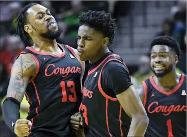  ?? ANDY NELSON — THE ASSOCIATED PRESS ?? Houston’s Terrance Arceneaux, center, celebrates his 3-point shot against Oregon with teammates J’Wan Roberts, left, and Jamal Shead on Nov. 20. The Cougars are No. 1 in the latest AP Top 25Poll for the first time since 1983.