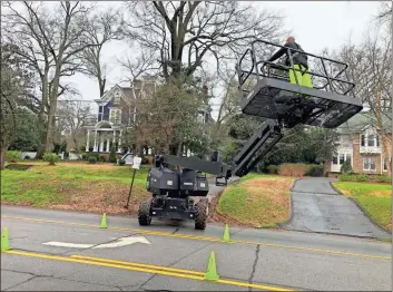  ?? K.T. Mckee ?? A member of a film support crew maneuvers a special lift at the Claremont House on the corner of Second Avenue and East 10th Street on Wednesday afternoon as local law enforcemen­t officers monitor traffic around it.