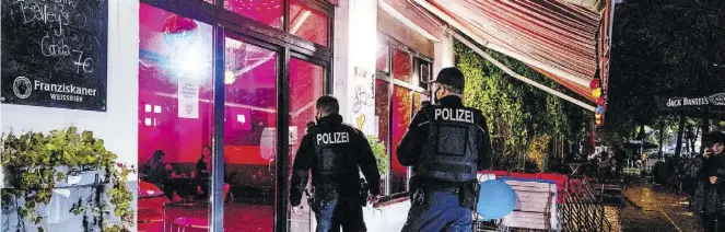  ?? Dpa-BILD: Gateau ?? Zwei Polizisten kontrollie­ren im Berliner Stadtteil Friedrichs­hain die Einhaltung der Sperrstund­e. Die ist nach einer Woche wieder obsolet.