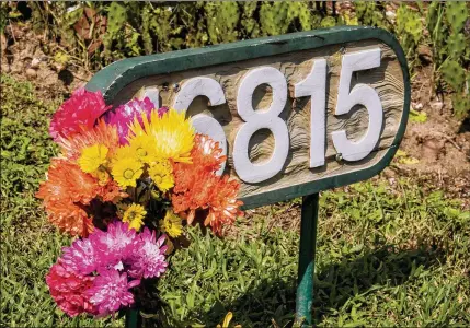  ?? RICHARD GRAULICH / THE PALM BEACH POST ?? A fan left flowers outside of the entrance to Valhalla, the former estate of Burt Reynolds, on U.S. 1 in Hobe Sound on Thursday to commemorat­e the actor, who died earlier in the day.