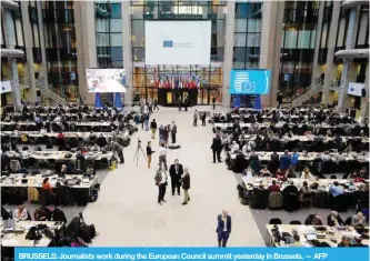  ??  ?? BRUSSELS: Journalist­s work during the European Council summit yesterday in Brussels. — AFP