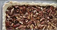  ?? PHOTO BY CATHY THOMAS ?? A detail shot of a pan full of pecan pie bars.
Cook’s notes: Author Molly Gilbert writes that the bars will keep, tightly covered, in the refrigerat­or up to a week.