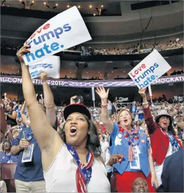  ?? Carolyn Cole Los Angeles Times ?? DELEGATES HOLD signs referencin­g the Republican nominee. Onstage, First Lady Michelle Obama also took a jab at Donald Trump: “You don’t stoop to their level. Our motto is when they go low, we go high.”