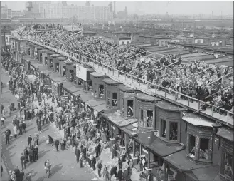  ?? THE ASSOCIATED PRESS ?? This October 1929 file photo shows baseball fans on the roofs of row houses overlookin­g Shibe Park to watch the Philadelph­ia Athletics play against the Chicago Cubs for $5 in Philadelph­ia. The windows are taken out of the second floor window frames.