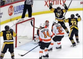  ?? GENE J. PUSKAR — THE ASSOCIATED PRESS ?? Pittsburgh Penguins center Sidney Crosby, far right, reacts after scoring the gamewinnin­g goal in overtime past Flyers goalie Brian Elliott on Monday.
