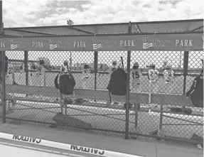  ?? RICARDO TORRES / MILWAUKEE JOURNAL SENTINEL ?? Players from the 6 Tool Baseball club team root for their teammates at bat on Saturday for their first game of the season, while caution tape prevents spectators from sitting behind the bench.