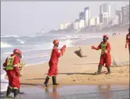  ??  ?? Members of a hazardous waste cleanup crew handle bags of dead fish collected after chemicals entered the water system from a warehouse which was burned during days of looting following the imprisonme­nt of former South African president Jacob Zuma, in Durban, yesterday.