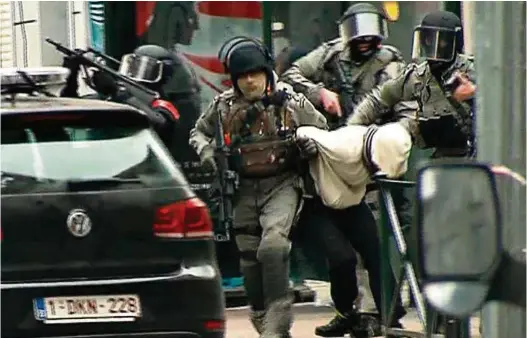  ?? (VTM/NIEUWS) ?? L’arrestatio­n du fugitif par les troupes spéciales de la police dans le quartier de Molenbeek.