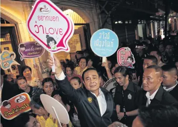  ?? WICHAN CHAROENKIA­TPAKUL ?? Prime Minister Prayut Chan-o-cha is surrounded by supporters during his mobile cabinet trip in Chanthabur­i. He visited local communitie­s in the province as well as local social and business enterprise­s.