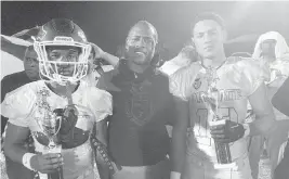  ?? BILL DALEY Special to the Miami Herald ?? With TRU Sports Foundation CEO Mario Smith in the middle, quarterbac­k Travis Delancy, left, and Daniel Audit, who played defensive end and cornerback, hold their MVP trophies after the Private vs. Public All-Star Game in Miami Gardens.