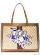  ?? Gucci ?? Gucci Ophidia GG tote in beige and ebony celebrates the Chinese calendar’s Year of the Pig with a blue-toned patch of Disney’s playful characters from “The Three Little Pigs.” $1,980. Available at gucci.com.