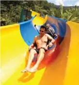  ??  ?? Sim Choo Kheng, center, Chief Executive Officer of Sim Leisure Group slide down on a floater on the world’s longest water slide at Escape theme park in Teluk Bahang, Malaysia.