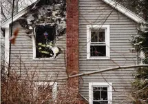  ?? Arnold Gold/Hearst Connecticu­t Media ?? A Hamden firefighte­r tosses charred debris from a home on Wintergree­n Avenue in Hamden on Friday.