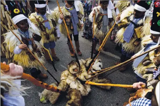  ?? (AP/Alvaro Barrientos) ?? Men dressed in sheepskins and cowbells act as though they are killing a bear Jan. 7 during the La Vijanera festival in Silio, Spain.