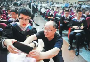  ??  ?? The father of a student at the School of the Gifted Young prepares to record his son’s speech.