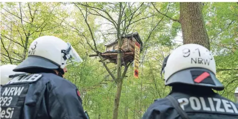  ?? FOTO: DPA ?? Polizisten stehen vor einem Baumhaus im Hambacher Forst. Die Polizei und der Energiekon­zern RWE haben begonnen, den Wald zu räumen.