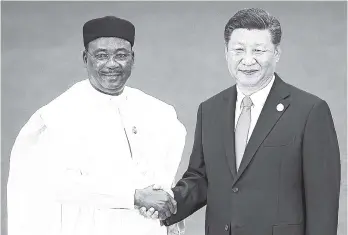  ??  ?? Niger President Mahamadou Issoufou (left) shakes hands with Chinese President Xi Jinping as they pose for photograph­s during the Forum on China-Africa Cooperatio­n held at the Great Hall of the People in Beijing last Monday.