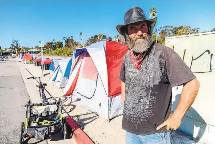  ?? DON BOOMER ?? Rodney Mcgough, 52, who is homeless, is one of 13 people living in tents alongside a stretch of South Oceanside Boulevard in Oceanside. The group keeps the area that was once full of litter clean.