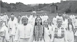  ??  ?? Maja (Isabelle Grill, center) participat­es in a ritual in “Midsommar.”