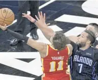  ?? PHELAN M. EBENHACK/AP ?? Hawks guard Trae Young (11) is fouled by Magic guard Michael CarterWill­iams (7) while going for a shot near the end of the second half Wednesday night at Amway Center.