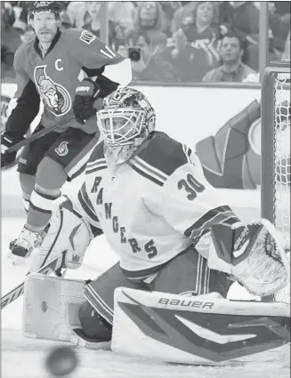  ?? Wayne Cuddington, Postmedia News ?? New York Rangers goalie Henrik Lundqvist deflects a shot as Ottawa Senators’ Daniel Alfredsson looks on during Game 6 of their Eastern Conference quarter-final in Ottawa on Monday.